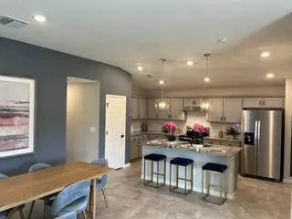 Model Home A stylish kitchen and dining area with sleek gray cabinets, pendant lighting, and a spacious island for entertaining.