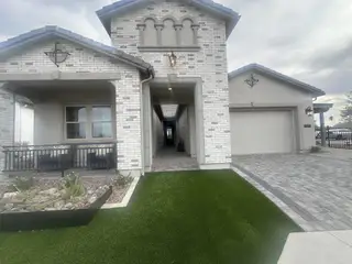 A charming home with stylish white brick and a manicured lawn in Earnhardt Ranch by Blandford Homes (Chandler, AZ).