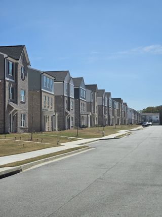 A row of elegant townhomes with brick facades in The Beacon at Old Peachtree by Stanley Martin Homes, Lawrenceville, GA.