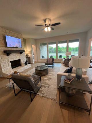 A cozy living room with a stone fireplace, plush seating, and large windows offering scenic views.