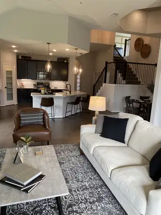 A modern open-plan living room with cozy seating, a stylish kitchen island, and elegant lighting fixtures.