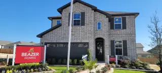 A beautiful brick home with charming shutters and lush landscaping in Bricewood by Beazer Homes (Helotes, TX).