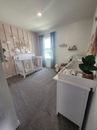 A cozy nursery with a cute white crib, soft carpeting, pastel decor, and a sunlit window creating a serene atmosphere.
