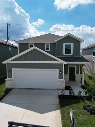 Street view A modern gray two-story home with a clean design and manicured lawn in University Village by Century Communities (San Antonio, TX).