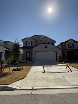 Street view A beautiful model home by Castlerock Communities with a well-manicured lawn and with red signage.