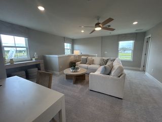 A cozy living area features a plush sectional, neutral tones, and ample natural light, creating a relaxing and inviting space.