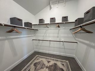 A neatly arranged walk-in closet with shelving, hangers, and storage bins for organization.