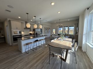 A sleek kitchen with white cabinetry, pendant lighting, and a spacious island.