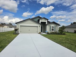 Charming gray home with a manicured lawn in Marion Oaks by LGI Homes, Ocala, FL.