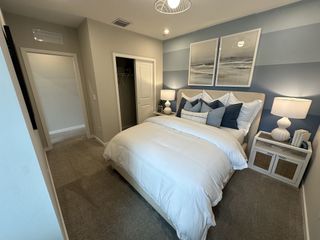 A cozy bedroom with a stylish blue accent wall, plush bedding, and elegant bedside lamps.