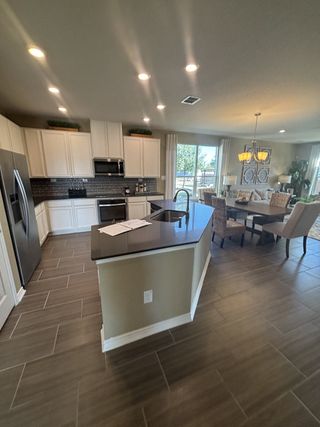 A modern kitchen with sleek cabinetry, stainless steel appliances, and an open layout connecting to a cozy dining area.