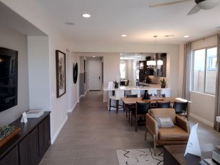 A modern open-concept living area with cozy seating, a stylish dining table, and a bright kitchen.