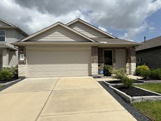 A charming brick and siding home with a tidy front yard in Breckenridge Forest by D.R. Horton (Spring, TX).
