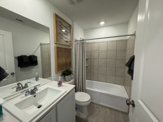 A modern bathroom featuring tile walls, sleek vanity, and stylish decor with warm tones and contemporary lighting.