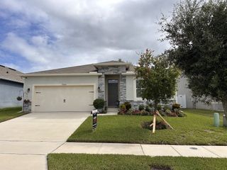 Street view Charming home with a landscaped yard and stone accents in Seasons at The Grove by Richmond American Homes (Mascotte, FL).