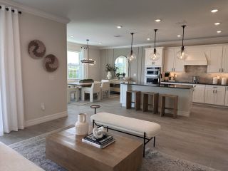 A spacious open-concept kitchen and living area with neutral tones, modern lighting, and sleek decor.