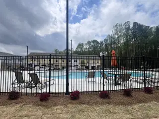 Community Amenities A lovely community pool area with lounge chairs and umbrellas in Aviary Park by Starlight Homes, Atlanta, GA.