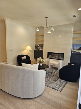 A chic living area with a modern fireplace, built-in shelves, and cozy seating, creating a perfect spot for relaxation.