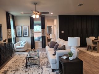 A modern living room with a cozy beige sofa, elegant décor, and contemporary lighting in a stylish open-concept space.