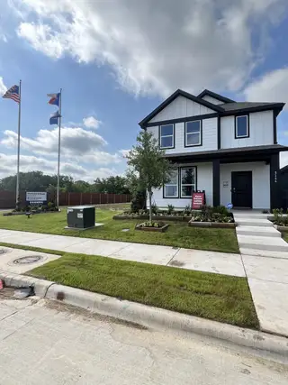Street view A modern black and white home with landscaped yard in Orchard Village by D.R. Horton (Fort Worth, TX).