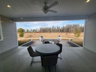 A serene patio with cozy seating, open views, and a ceiling fan, perfect for outdoor relaxation.