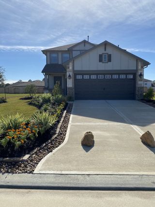 Street view A charming two-story home with manicured landscaping in Granger Pines by First America Homes (Conroe, TX).