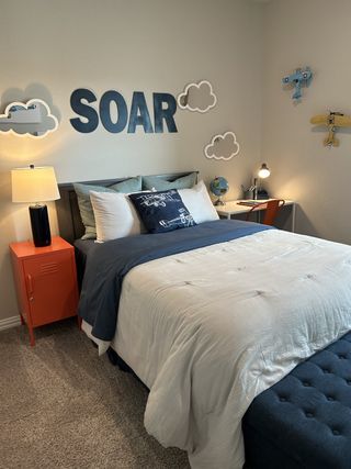 Model Home A playful aviation-themed bedroom with bold decor, vibrant pops of color, and cozy furnishings, ideal for creativity and comfort.