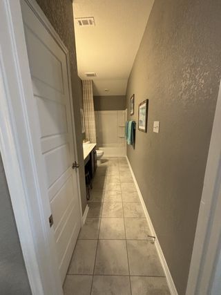 A modern bathroom with light tiled floors, neutral walls, and a sleek vanity, offering a clean and inviting atmosphere.