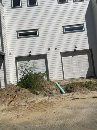 Street view A modern white home with dual garage doors in Walk at Park Circle by CK Development, North Charleston, SC.