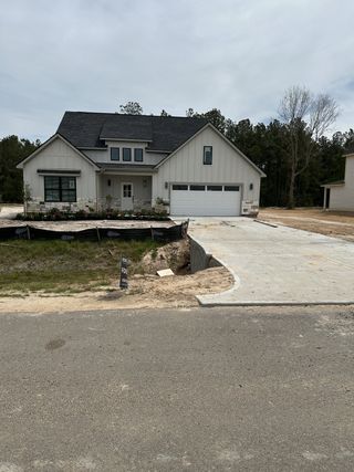 Charming modern farmhouse with dark roof and elegant landscaping in Spring Branch Crossing by ICONIQ Homes (Granbury, TX).