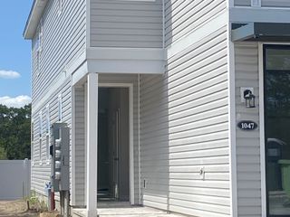 A modern gray siding home featuring a quaint porch in Egret Creek by Mattamy Homes (Jacksonville, FL).