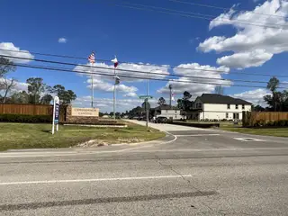 A charming community entrance with flags at Cypresswood Point by Long Lake Ltd. in Humble, TX.
