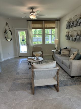 A cozy living room with modern decor, neutral tones, a comfy couch, and stylish wall hangings.