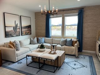 A cozy living room with a spacious beige sectional, artistic wall decor, and elegant blue accents.