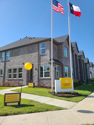 Street view A modern brick home with elegant windows and flags in Mosaic by Cadence Homes, Celina, TX.