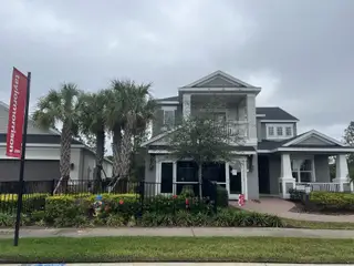 A stunning modern home with a covered balcony and lush landscaping in River Landing by Taylor Morrison (Wesley Chapel, FL).