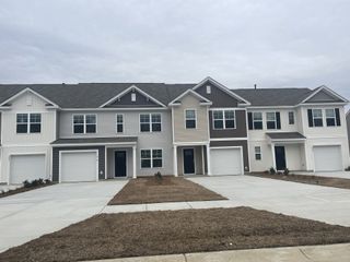Modern townhomes with diverse siding and neat lawns in Pine Hills Townhomes at Cane Bay by D.R. Horton (Summerville, SC).