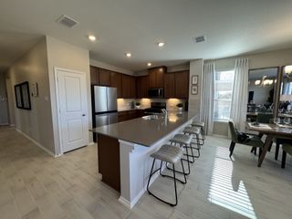 A modern kitchen with a spacious island, sleek appliances, and a cozy dining area with elegant lighting.
