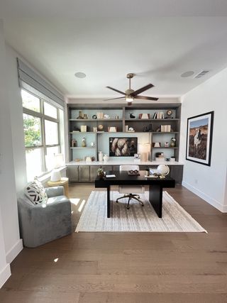 Model Home A modern home office with sleek shelving, elegant decor, and a large window for natural light.