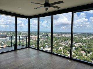 A breathtaking high-rise corner view with expansive floor-to-ceiling windows overlooking the city skyline.