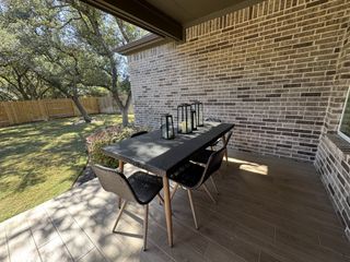 A dedicated outdoor dining area on the patio, featuring a black dining table and chairs, creating an inviting atmosphere for al fresco dining.