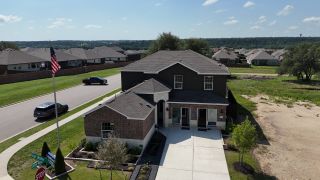 Street view A charming brick home with manicured landscape in Lively Ranch: Brookstone Collection by Lennar (Georgetown, TX).