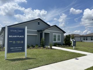 Street view A modern gray house with manicured landscaping in Belair Place by Starlight Homes (Sanford, FL).