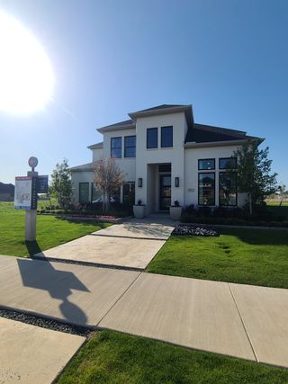 A modern two-story home with lush landscaping in Painted Tree - South by Normandy Homes (McKinney, TX).