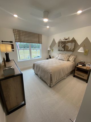 A cozy bedroom featuring a checkered window treatment, patterned bedding, and stylish wall art for a modern touch.