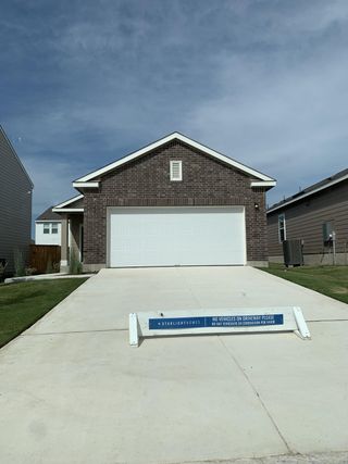 A charming brick home with a spacious driveway in Sonterra by Starlight Homes (Jarrell, TX).