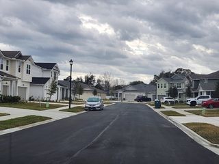 Street view Charming suburban street view in Olde Mandarin Estates by Mattamy Homes, featuring modern houses in Jacksonville, FL.