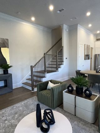 A modern living area with elegant seating, artistic decor, and a sleek staircase, blending style and function seamlessly.
