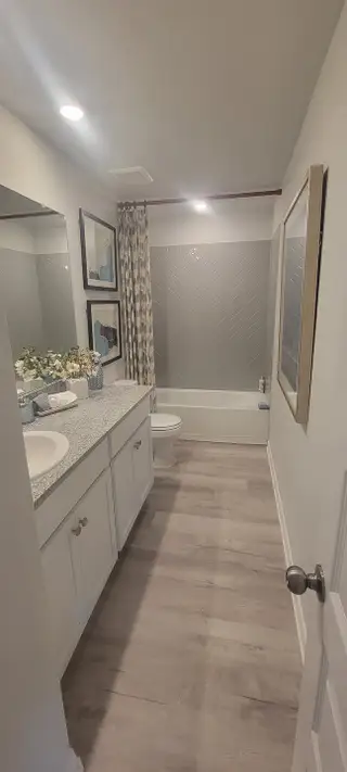 A modern bathroom featuring a sleek vanity, elegant herringbone wall tiles, and stylish decor elements.