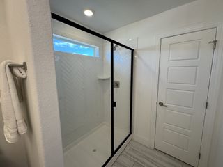 A luxurious glass shower featuring white herringbone tile, black trim, and a sleek design, bringing a contemporary touch to the bathroom.